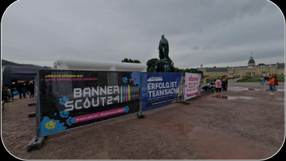 Ein Banner und viele Menschen im Schlamm zu Fuß
