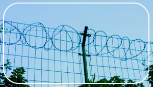 Stacheldrahtzaun vor blauem Himmel.